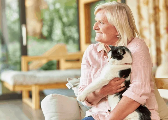 senior lady holding a cat around her arms