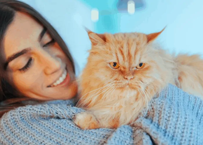 woman with a blue jacket talking to her cat