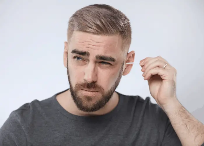 man removing his earwax 